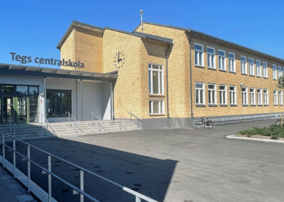Ingången till Teg centralskola, med utsikt över cykelparkeringen vid tegelväggen på byggnaden.