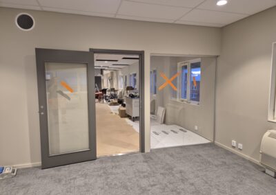 Kontorsrum med monterade glaspartier och ny heltäckningsmatta.