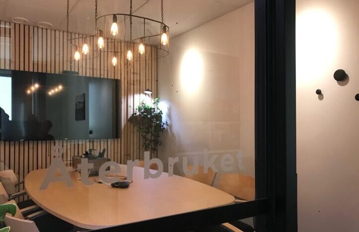 inglasat konferensrum med texten "Återbruket" på glaset.