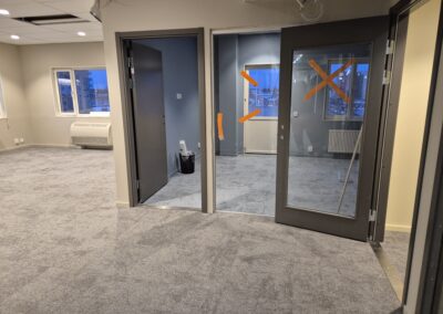 Kontorsyta med glasväggar och dörrar markerade inför justering.