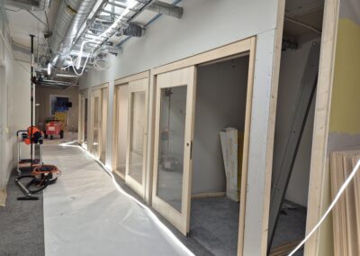 Korridor med nyinstallerade dörrpartier och synlig installation i tak.