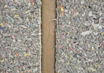 Detaljbild av återvunnet isoleringsmaterial monterat i vägg.