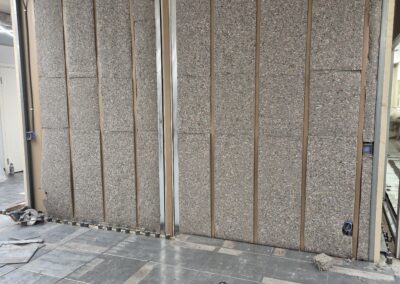 Väggstomme med monterad isolering och förberedelser för ytskikt.